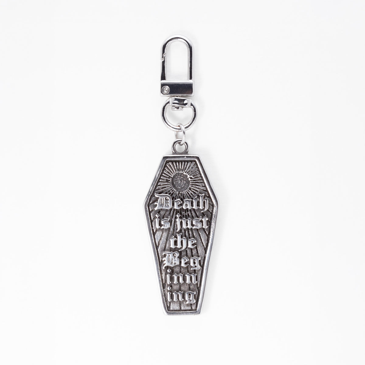 A stainless steel gothic coffin-shaped keychain bag charm with the gothic text 'Death is just the Beginning' and a sunburst design, attached to a silver lobster clasp on a white background.