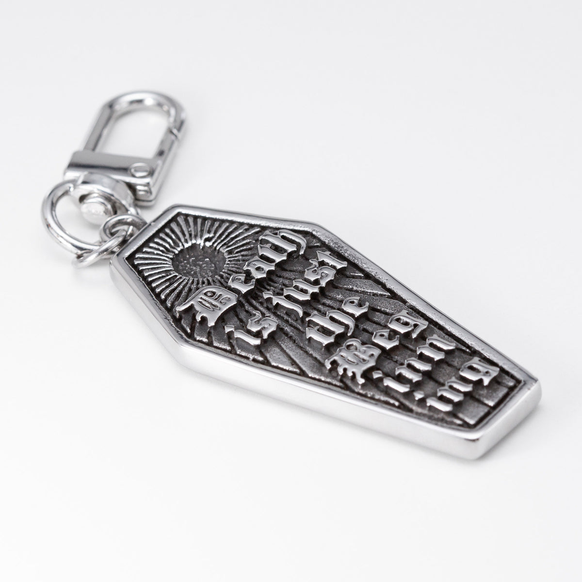 A silver coffin-shaped keychain charm with an engraved sunburst and the words 'Death is just the beginning' in gothic lettering, attached to a silver lobster clasp on a white background.