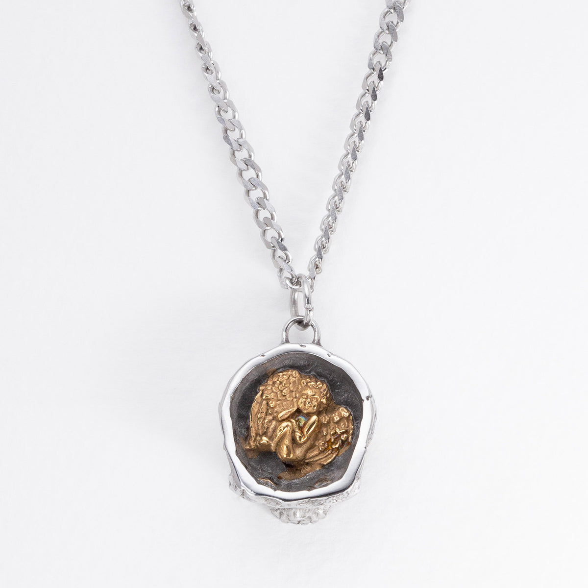 Top view of the Nick Von K Rebirth skull charm showing a gold-toned angel relief in a dark circular setting.