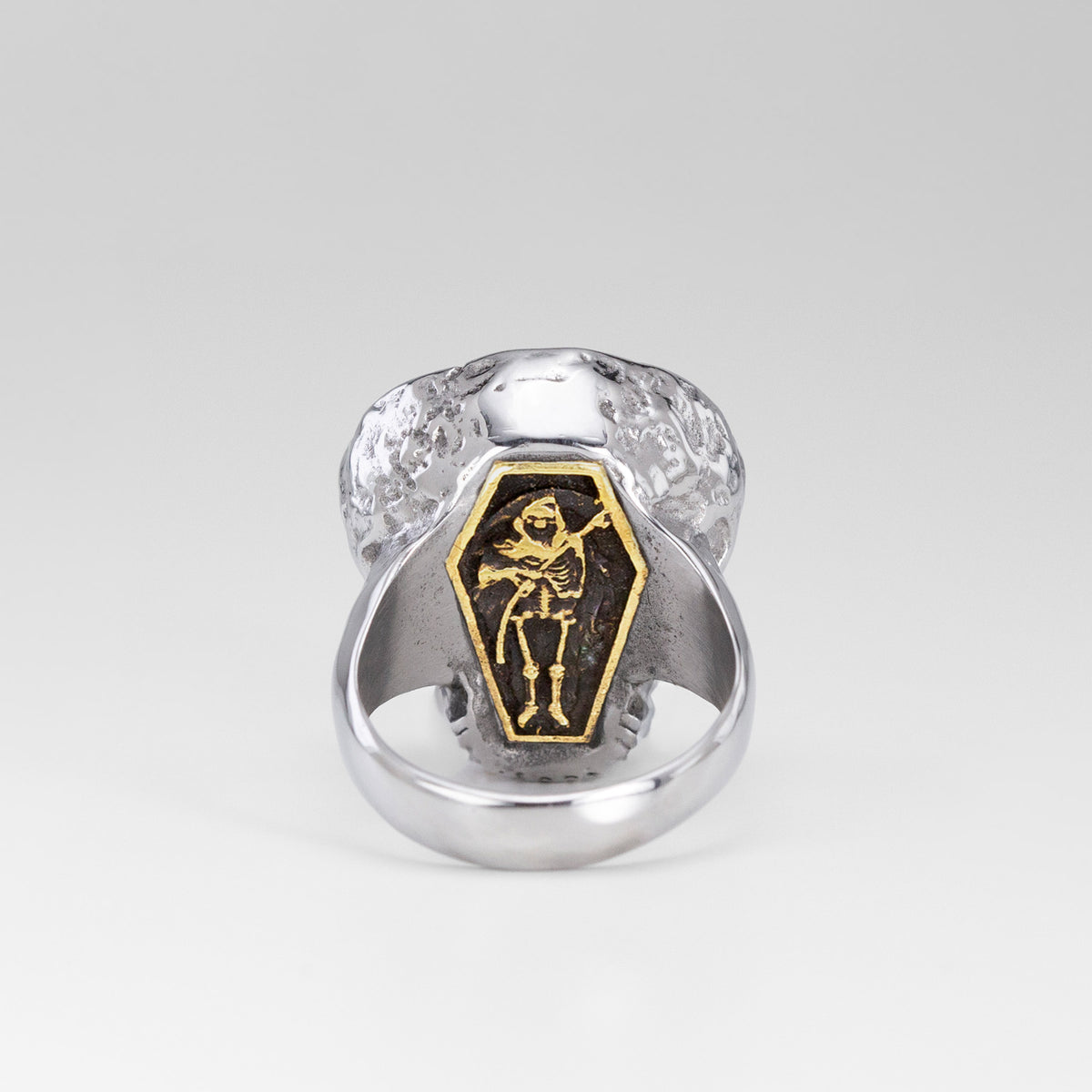 Rear view of the Nick Von K Rebirth skull ring showing a gold-outlined coffin with a skeletal reaper and scythe.