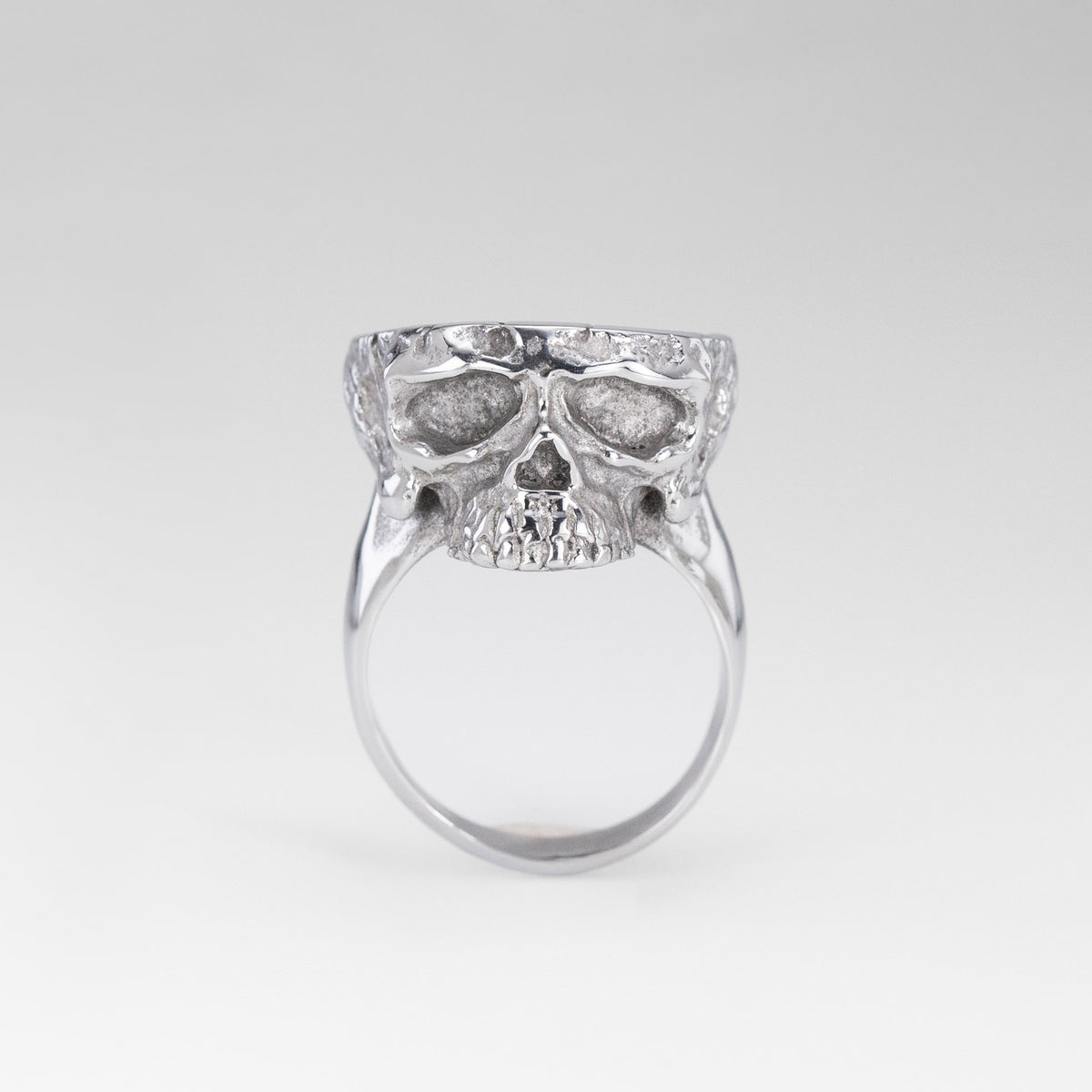 Front view of the Nick Von K Rebirth ring with a sculpted silver-toned skull face and smooth band.