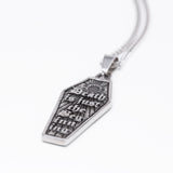 A silver coffin-shaped pendant necklace with the gothic text 'Death is just the beginning' engraved on a textured background, shown on a clean white background.