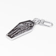 A stainless steel gothic coffin-shaped keychain featuring an embossed skeleton grim reaper design, complete with a metal carabiner clasp, shown on a plain white background.
