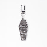 A stainless steel gothic coffin-shaped keychain bag charm with the gothic text 'Death is just the Beginning' and a sunburst design, attached to a silver lobster clasp on a white background.