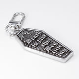 A silver coffin-shaped keychain charm with an engraved sunburst and the words 'Death is just the beginning' in gothic lettering, attached to a silver lobster clasp on a white background.