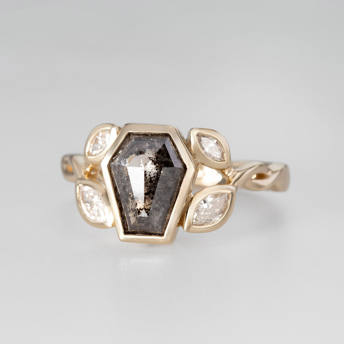 Nick Von K 9 Karat Yellow Gold Ring with Coffin Shaped Salt and Pepper Diamond bezel set and accented by Marquise shaped lab diamonds and twisted vines side angle