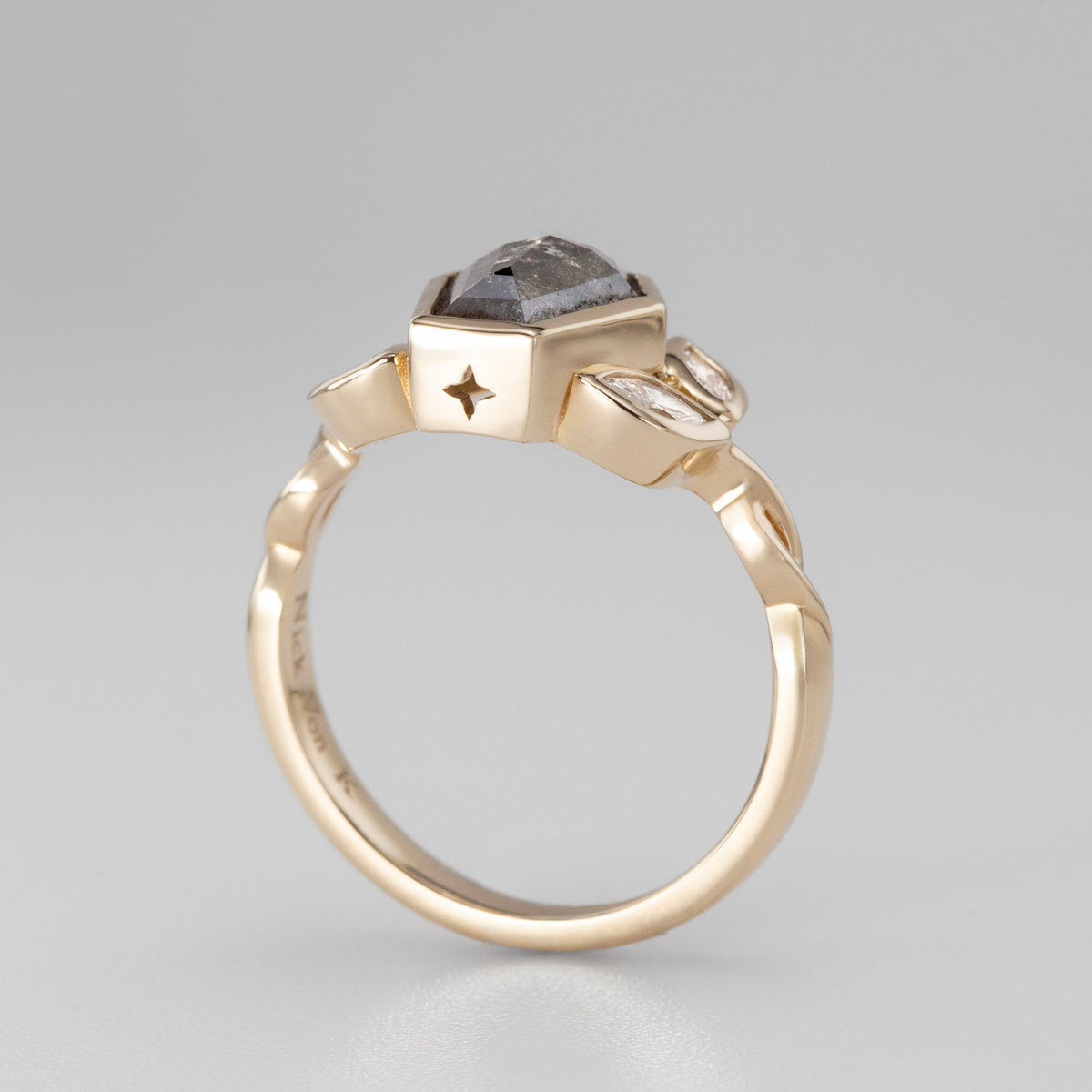 Nick Von K 9 Karat Yellow Gold Ring with Coffin Shaped Salt and Pepper Diamond bezel set with star cut out and accented by Marquise shaped lab diamonds and twisted vines side angle