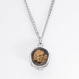 Top view of the Nick Von K Rebirth skull charm showing a gold-toned angel relief in a dark circular setting.