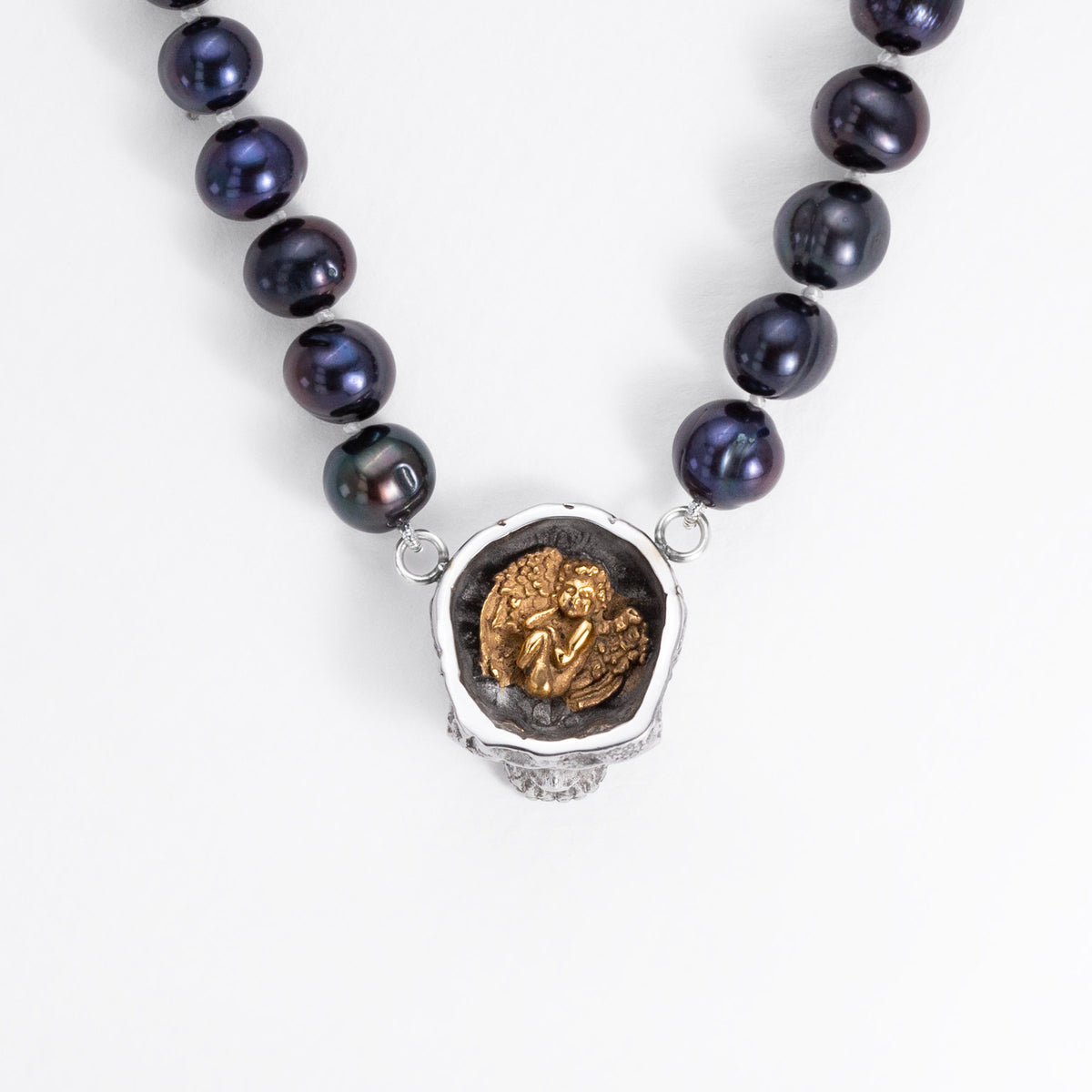 Top detail of the Nick Von K Rebirth pearl necklace showing a gold-outlined coffin and skeletal reaper on the skull pendant.