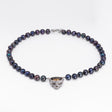 Nick Von K Rebirth necklace with dark iridescent pearls and a skull pendant topped by a gold-toned angel relief.