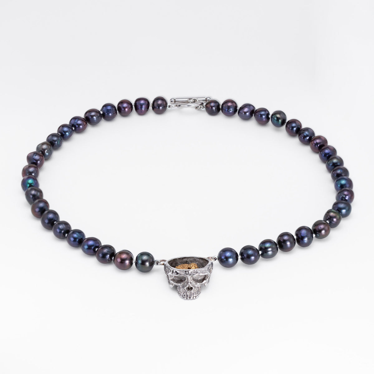 Nick Von K Rebirth necklace with dark iridescent pearls and a skull pendant topped by a gold-toned angel relief.
