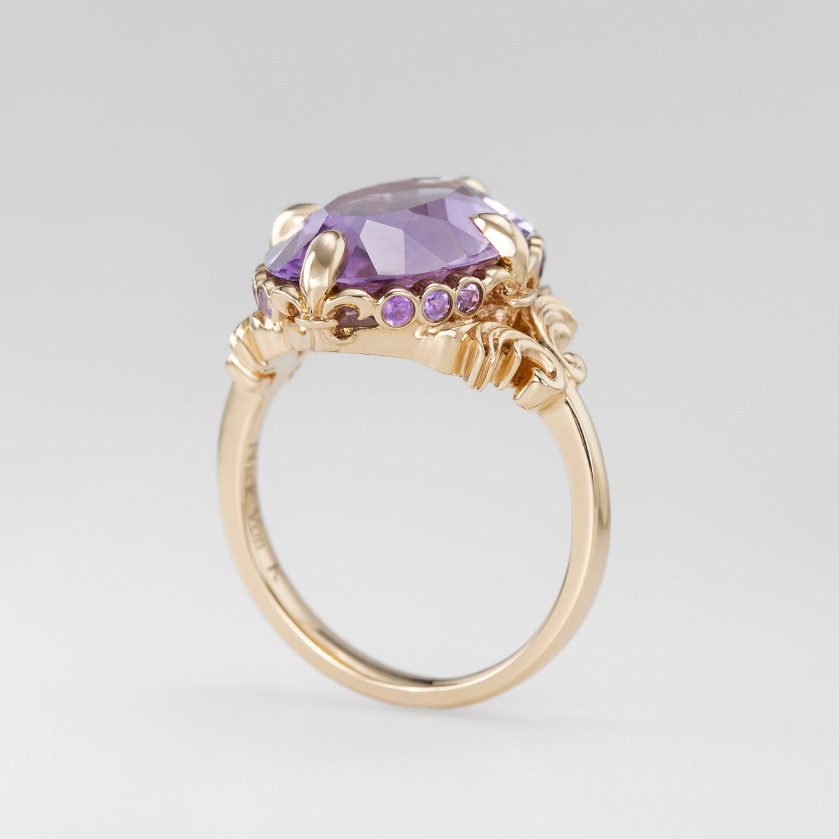 Nick Von K 9k Yellow Gold Royal Unicorn Ring with Amethyst side view of fleur-de-lis claw setting and small gypsy set round cut Amethysts