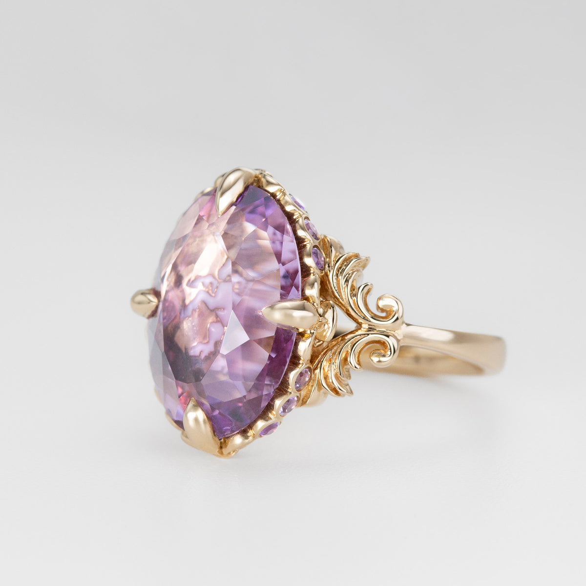 Nick Von K 9k Yellow Gold Royal Unicorn Ring with Amethyst side view of fleur-de-lis claw setting and small gypsy set round cut Amethysts