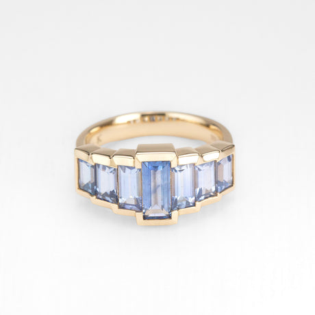 Gold ring with blue sapphires on a white background