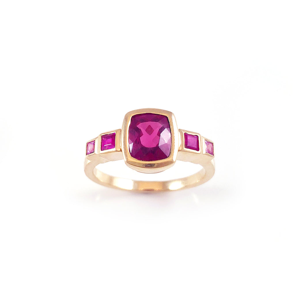 Royalty ring with a Dark Pink Rhodolite Garnet in between Rubies and Sapphires in 9 carat Yellow Gold